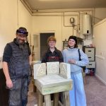 three people with completed stone carvings